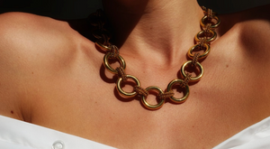 Female wearing gold rope link necklace and white shirt